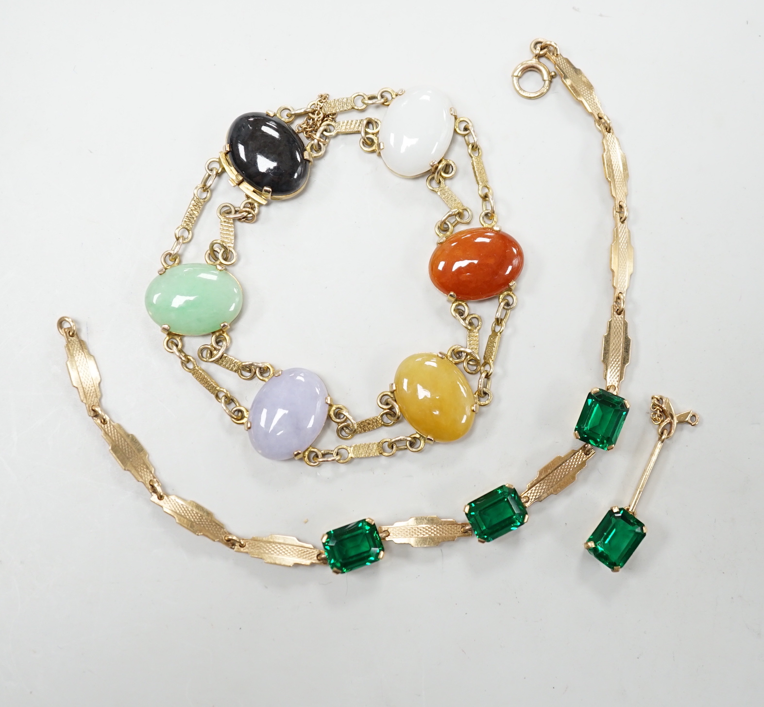 A yellow metal and semi precious cabochon stone set bracelet, 16cm, together with a 9ct gold and green stone set bracelet and one earring.